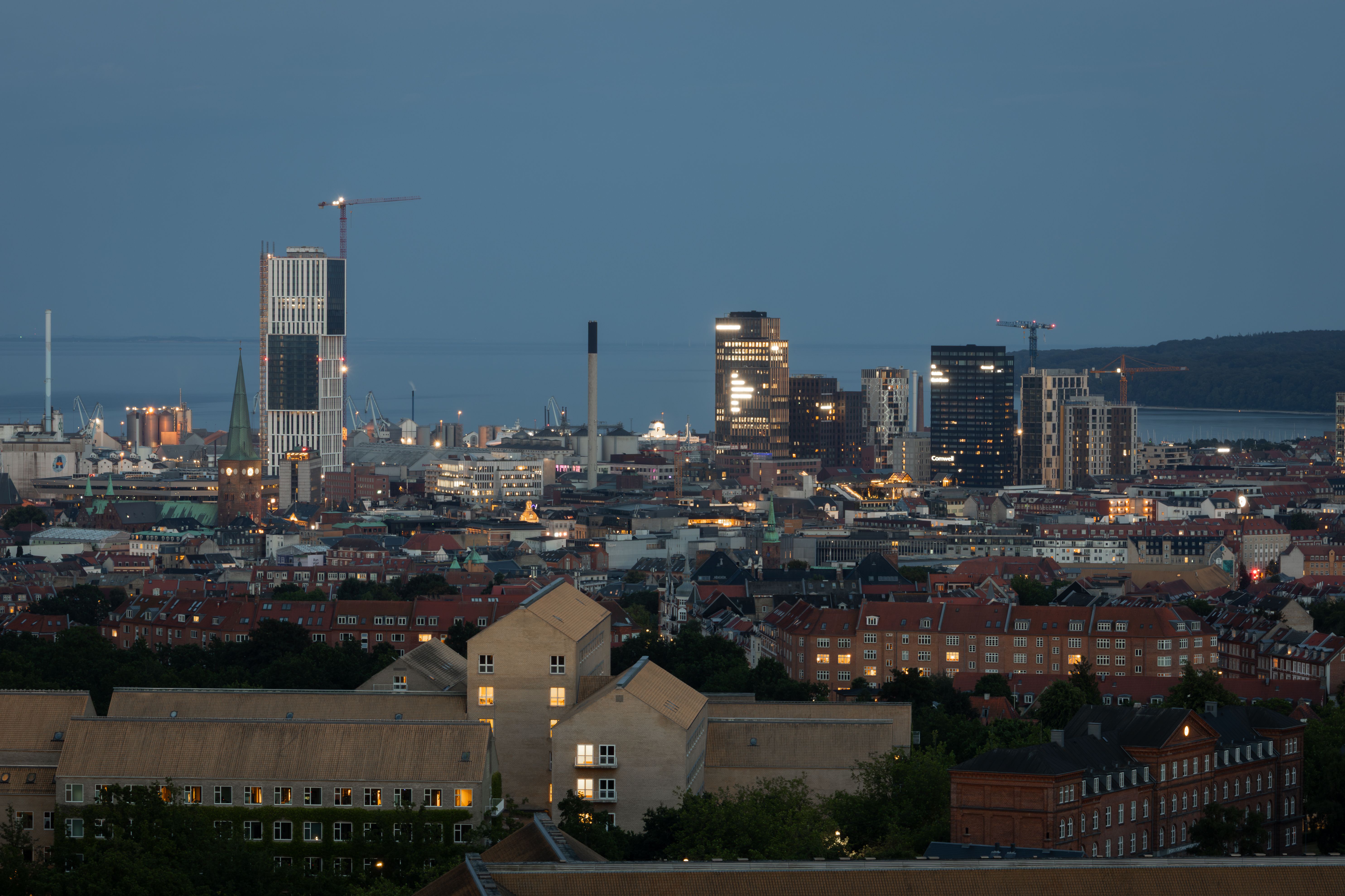 Skyline of Aarhus at twilight, showcasing modern architecture and waterfront views.