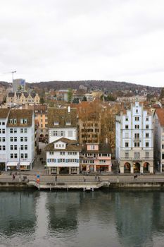 Picturesque view of Zurich's historic buildings reflecting on the river under a winter sky.