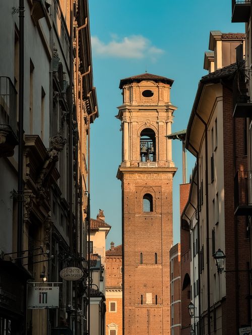 Free Historic bell tower view in Turin, Italy, captured between narrow streets with clear blue sky. Stock Photo