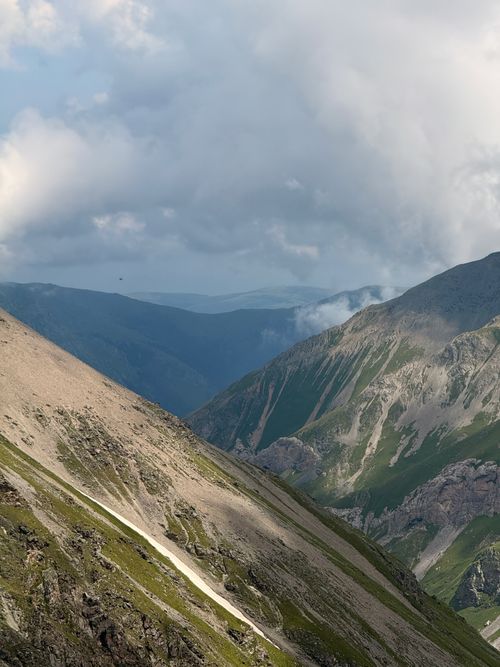 Free Stunning view of the Caucasus mountains with dramatic clouds and lush valleys. Stock Photo
