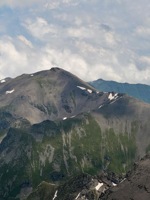 Free A breathtaking view of the rugged Caucasus mountains under a partly cloudy sky. Stock Photo