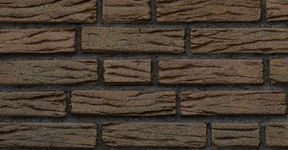 Close-up view of a textured brown brick wall, perfect for backgrounds or architectural design concepts.