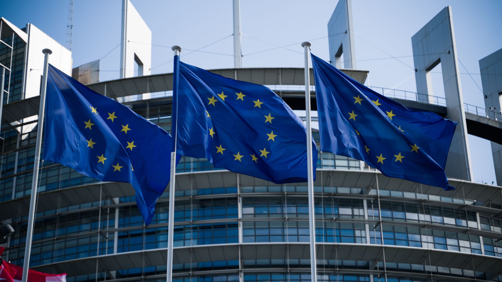 European Union flags waving outside the European Parliament in Strasbourg.