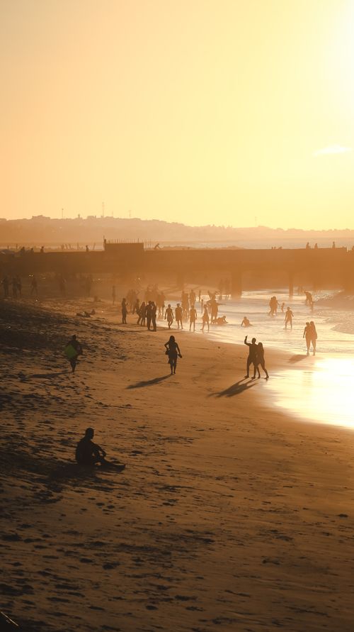 Free People enjoy a golden sunset at a beach in Ceará, Brazil, highlighting the vibrant coastal atmosphere. Stock Photo