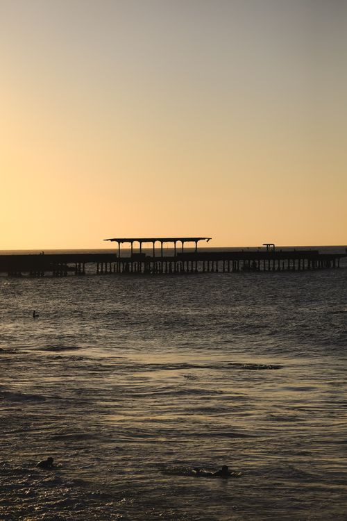 Free Golden sunset over Iracema Pier in Ceará, Brazil with calm seawater and silhouettes. Stock Photo