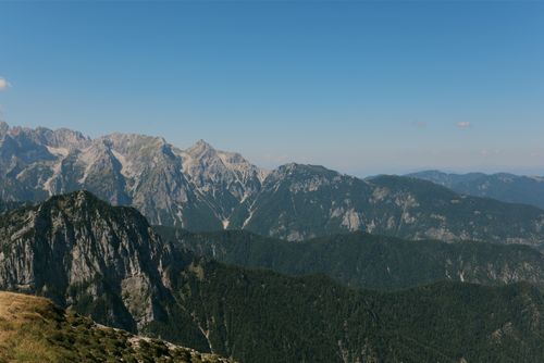 Free Panoramic view of a remote mountain range under a clear blue sky, ideal for nature enthusiasts. Stock Photo