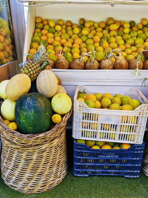 Free Vibrant assortment of fruits including melons and pineapples at a market in Göcek, Türkiye. Stock Photo