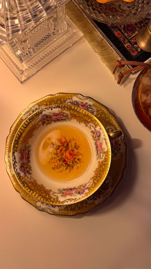 Free Top view of an ornate porcelain teacup with floral design on a cozy indoor setting. Stock Photo