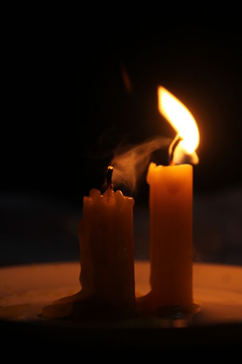 Free Atmospheric close-up of a glowing candle flame against a dark background. Stock Photo