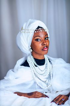 A woman in traditional attire adorned with pearls, showcasing cultural elegance.