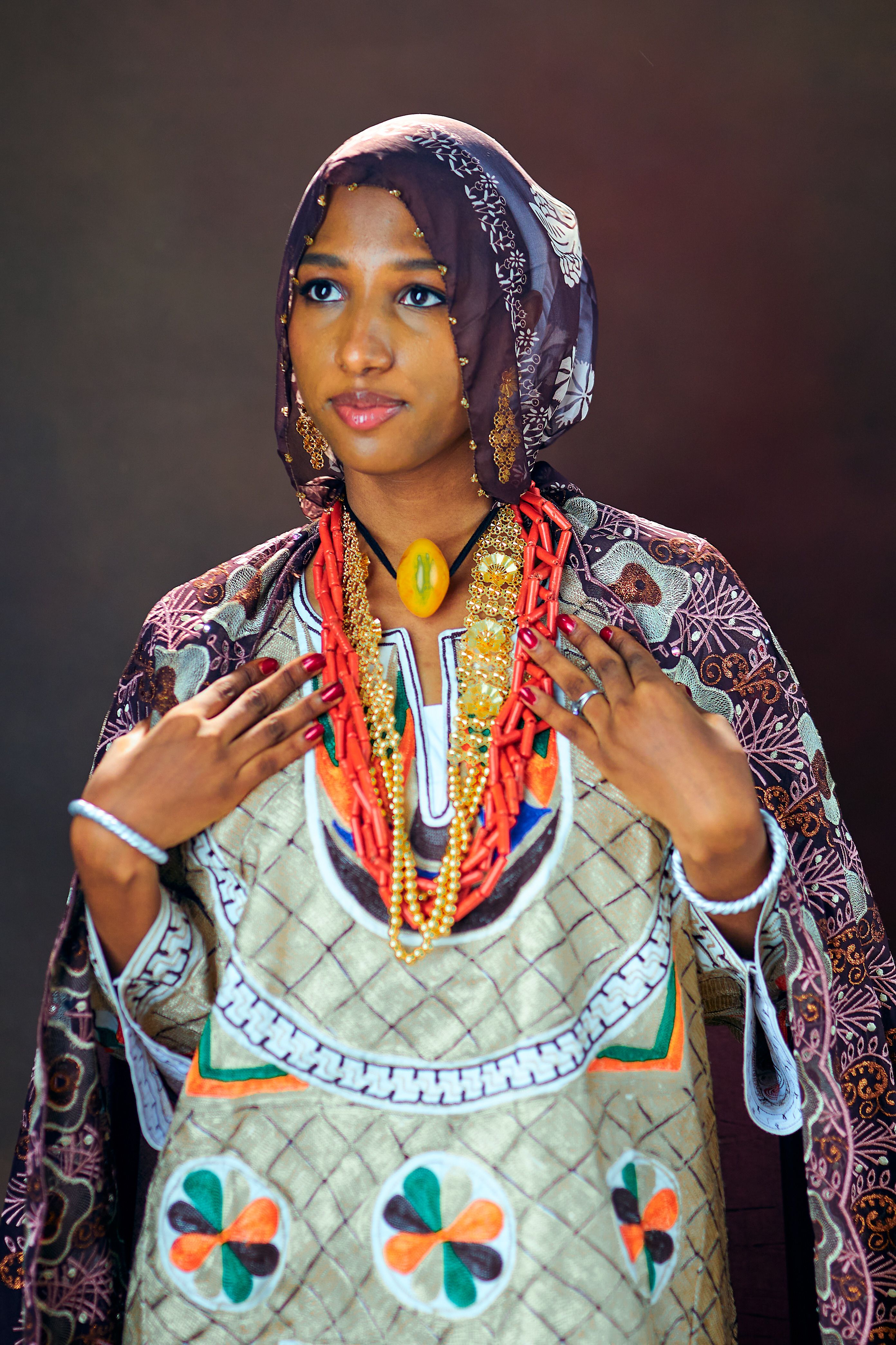 A woman in elaborate traditional Nigerian clothing and jewelry, showcasing cultural heritage.