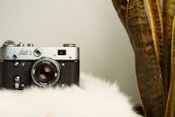 Black And Silver Camera On White Fur Textile