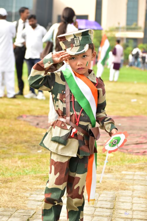 Free A young child salutes in military attire with Indian flag face paint during Independence Day celebrations. Stock Photo
