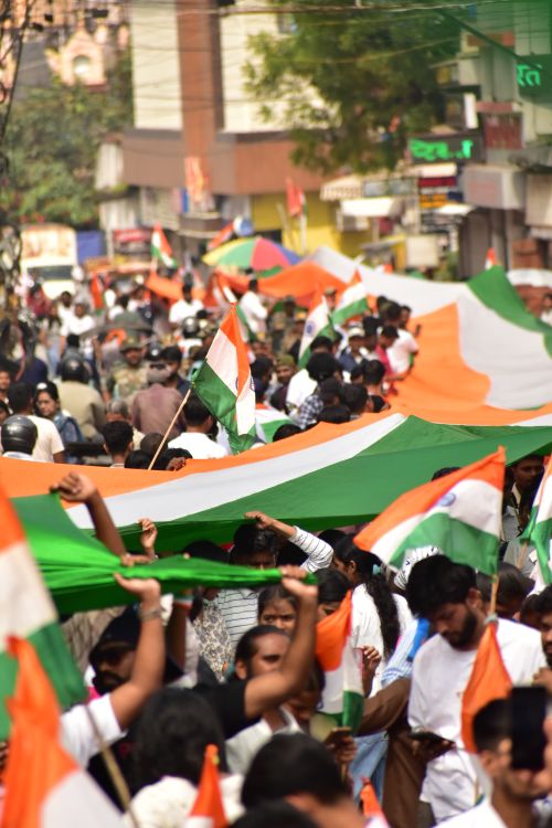 Free A vibrant street parade in Ranchi, India, celebrating with Indian flags held by participants. Stock Photo