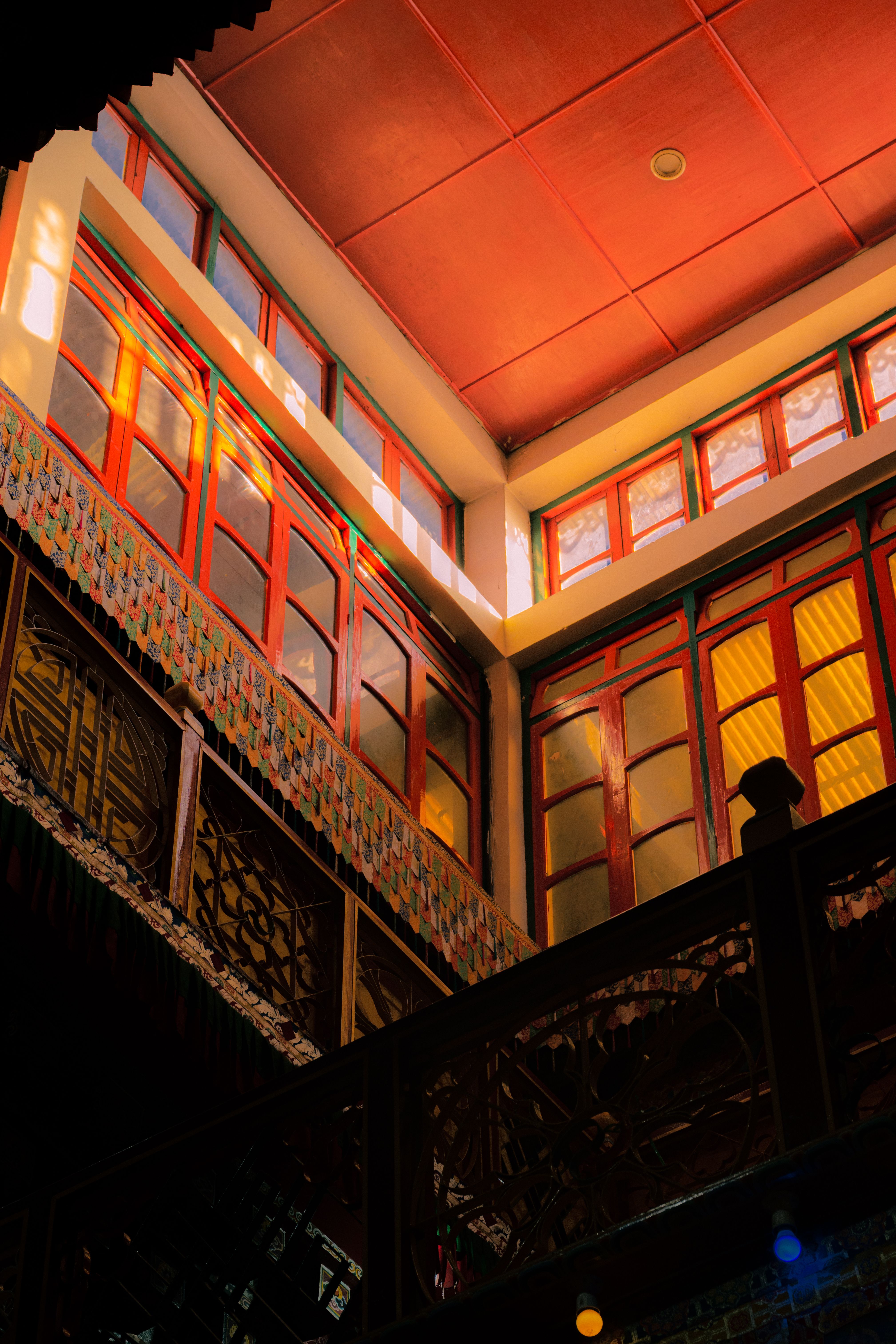 Sunlight illuminating vibrant woodwork in a traditional Tawang building interior.