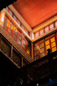 Sunlight illuminating vibrant woodwork in a traditional Tawang building interior.