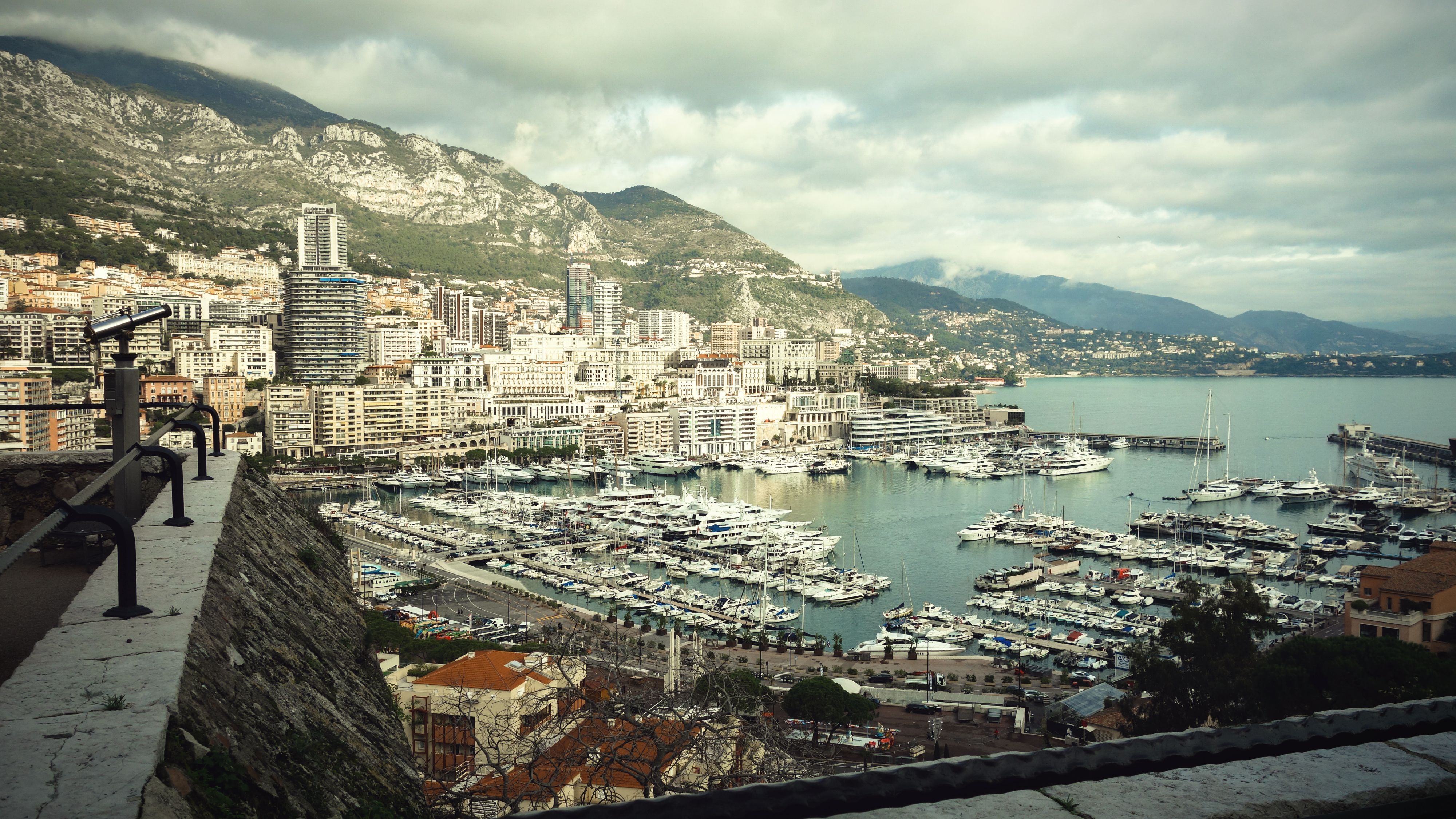 From above view from observation deck of bay with boats and yachts surrounded by houses and mountains