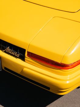 Detailed view of a yellow sports car tail light, featuring sleek design and vibrant color.