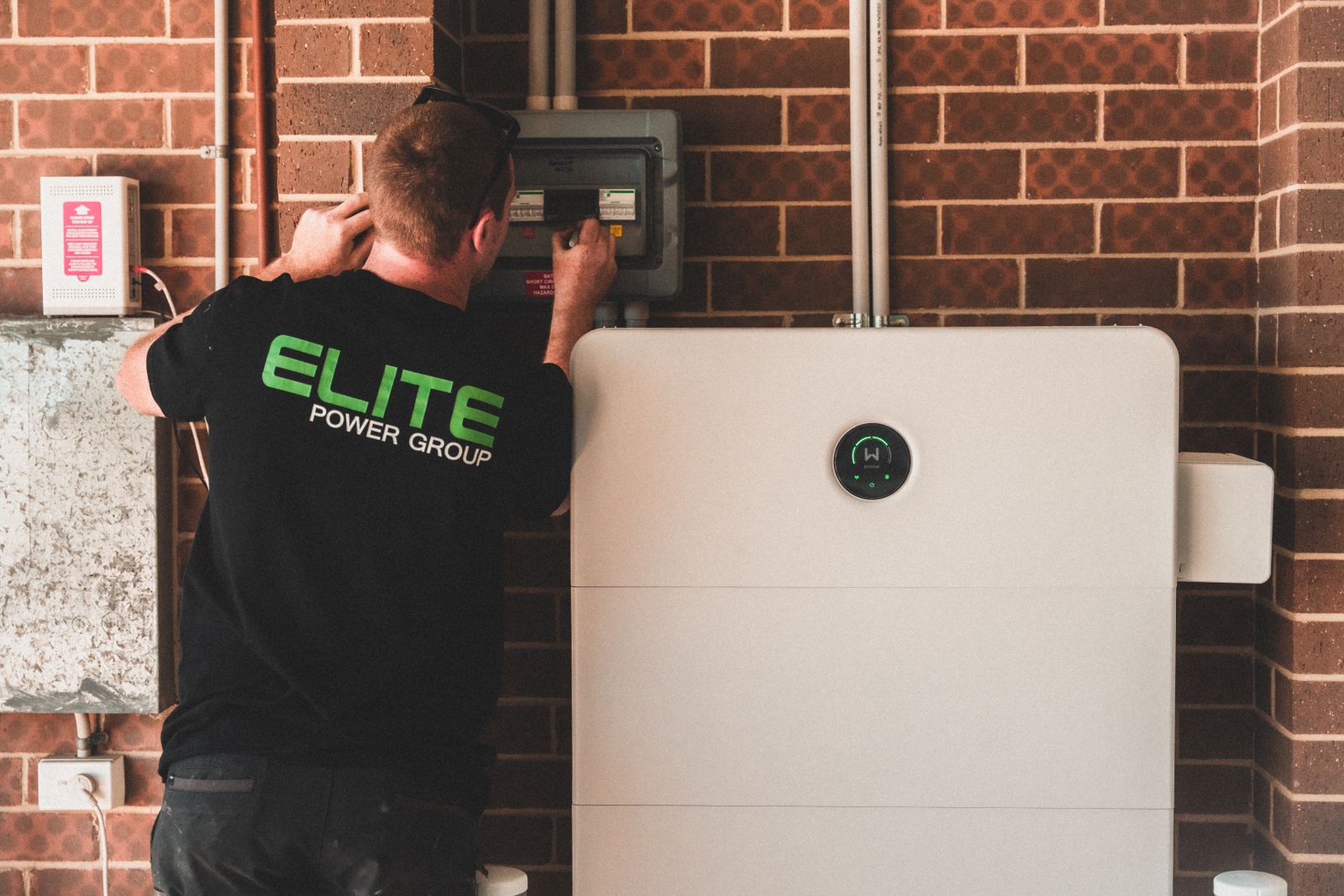 Home battery storage unit being installed beside a solar PV system in a Moray property