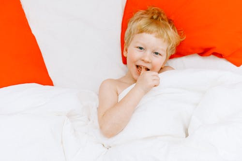 Topless Boy Lying On Bed