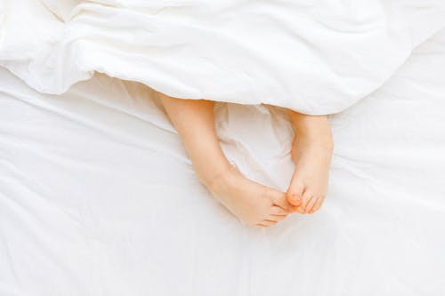 Free Person Lying On White Bed Stock Photo