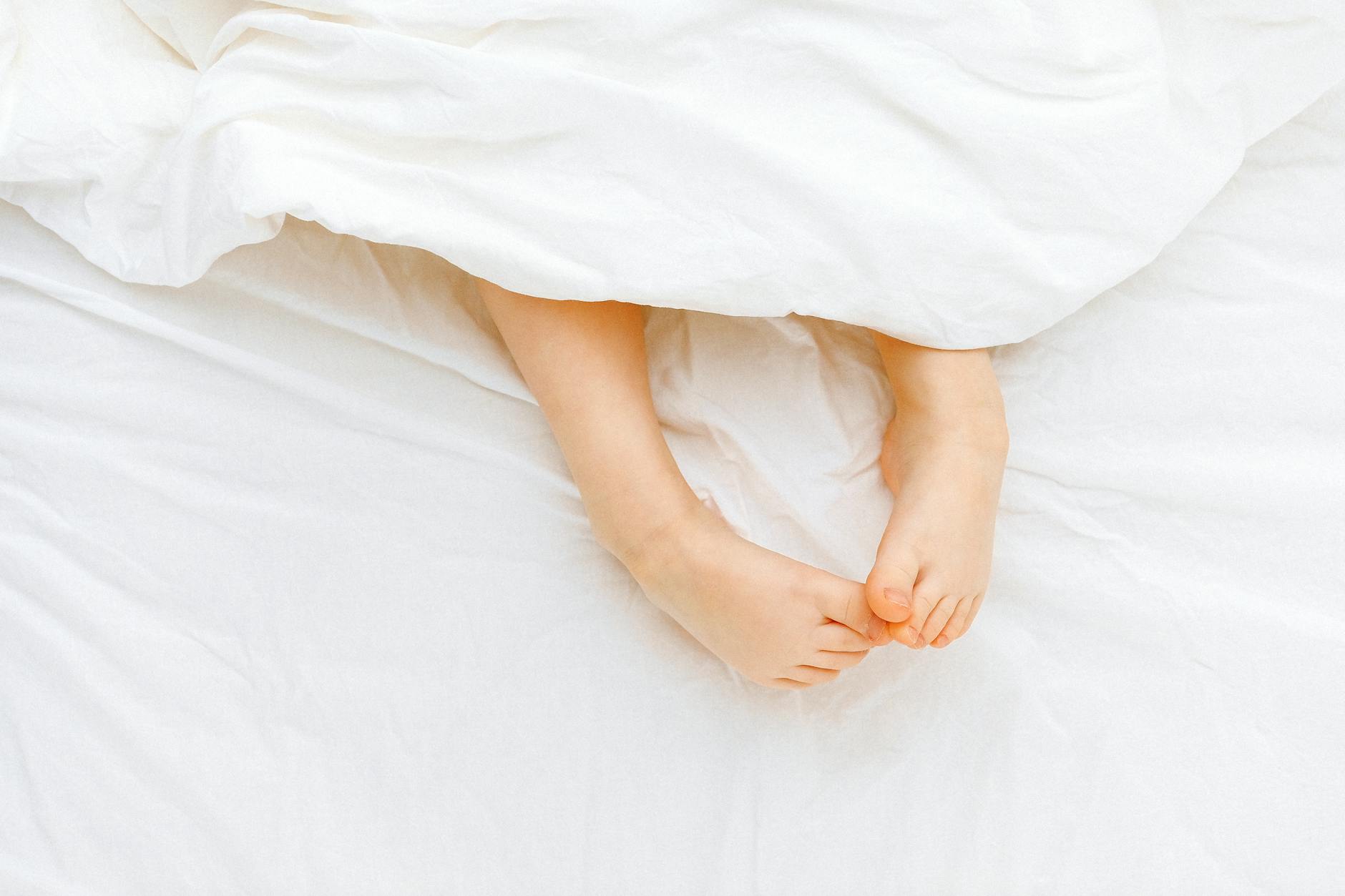 Person laying in white bed