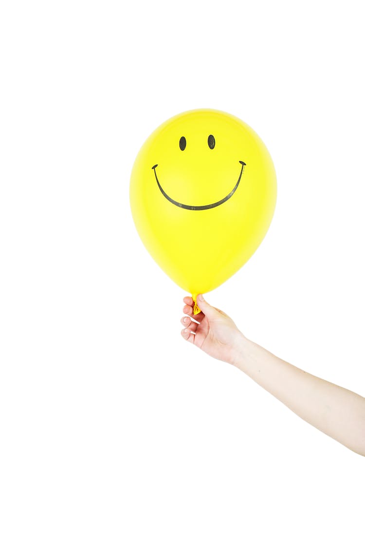 Person Holding Yellow Smiley Balloon