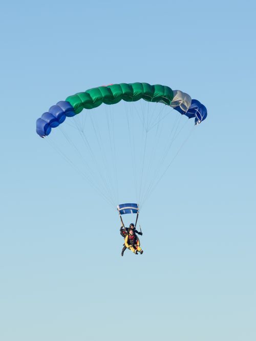 Free Exciting tandem skydiving experience over Buenos Aires with colorful parachute. Stock Photo