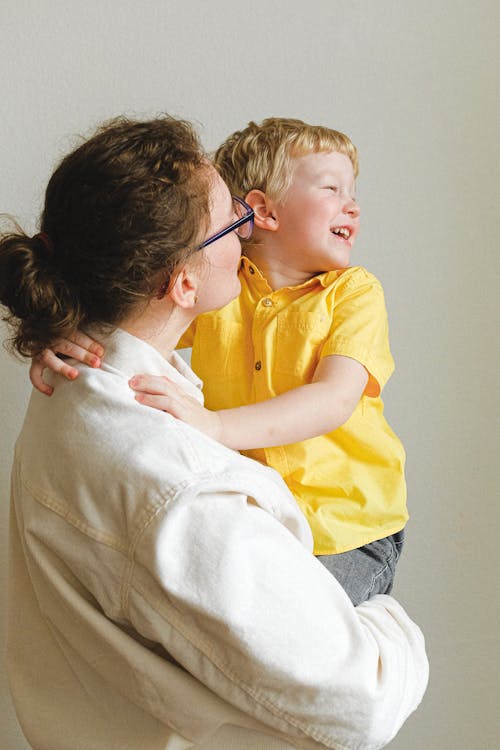 Woman Carrying Boy Wearing Yellow Polo Shirt