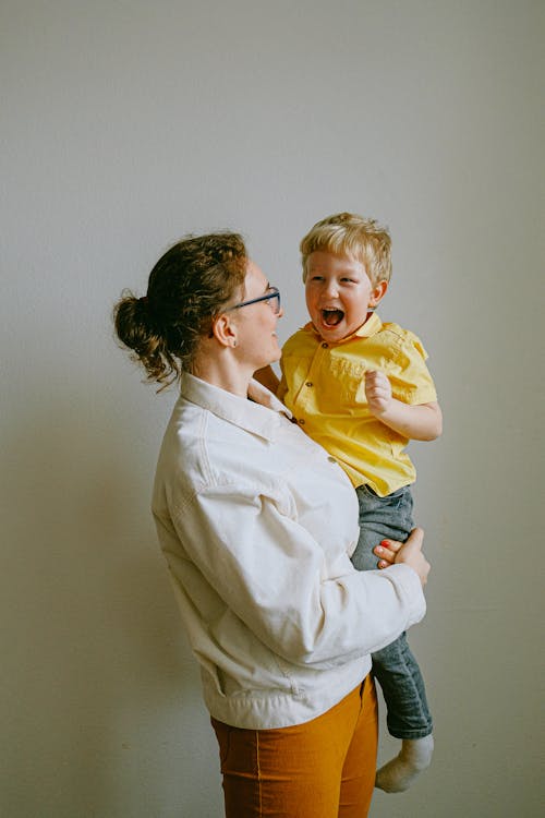 Woman Carrying A Boy In Yellow Polo