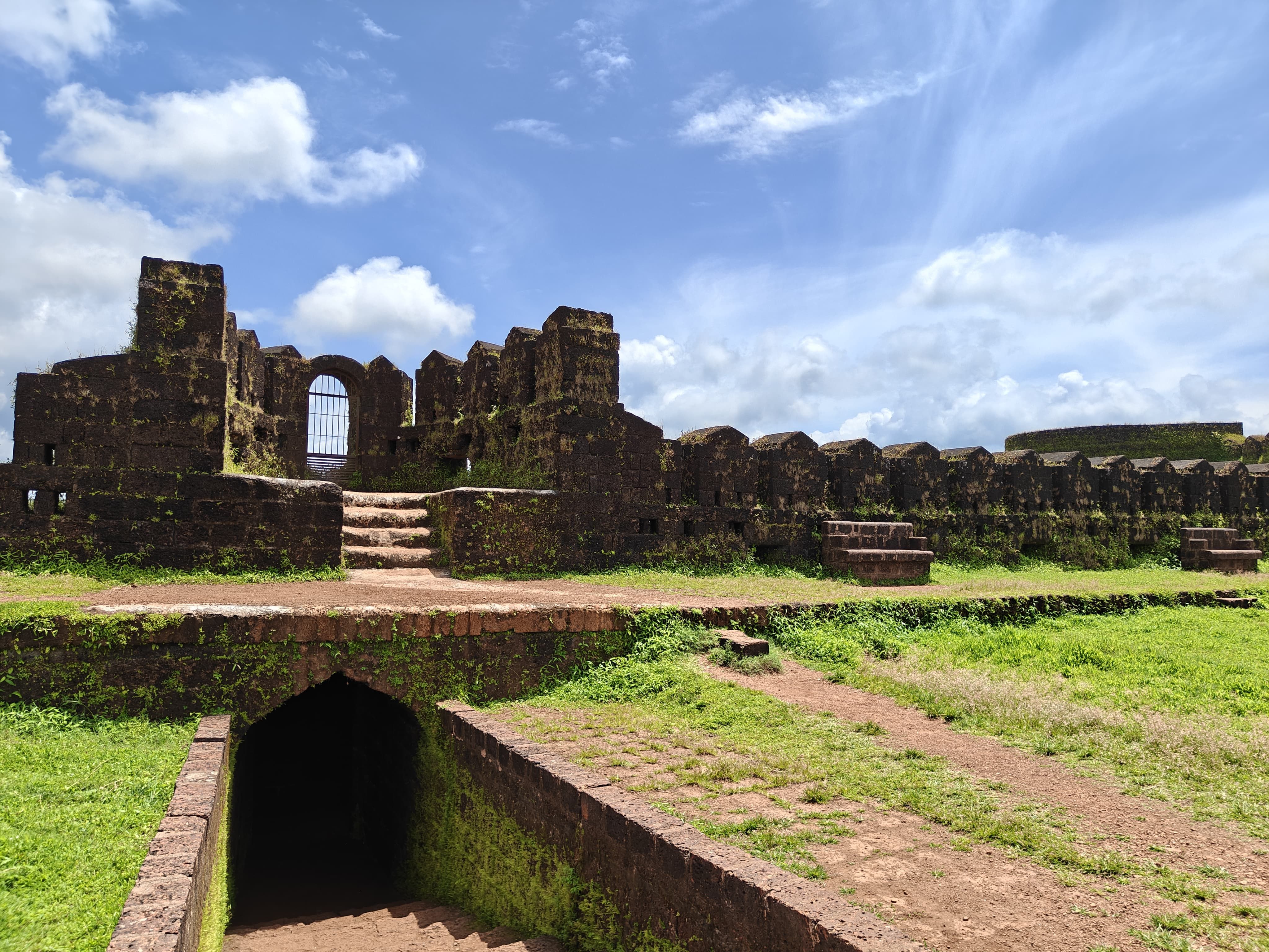 Ruined stone ramparts of a coastal fort with the sea beyond