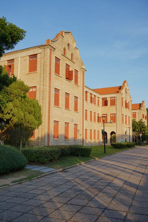 Free Elegant university building with red windows, captured in warm daylight. Stock Photo