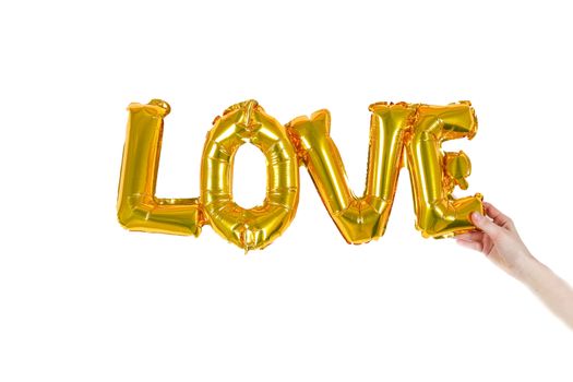 A set of golden 'LOVE' balloons held by a hand on a white background, symbolizing affection.