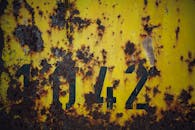 Yellow Rusty Wall With Numbers Written