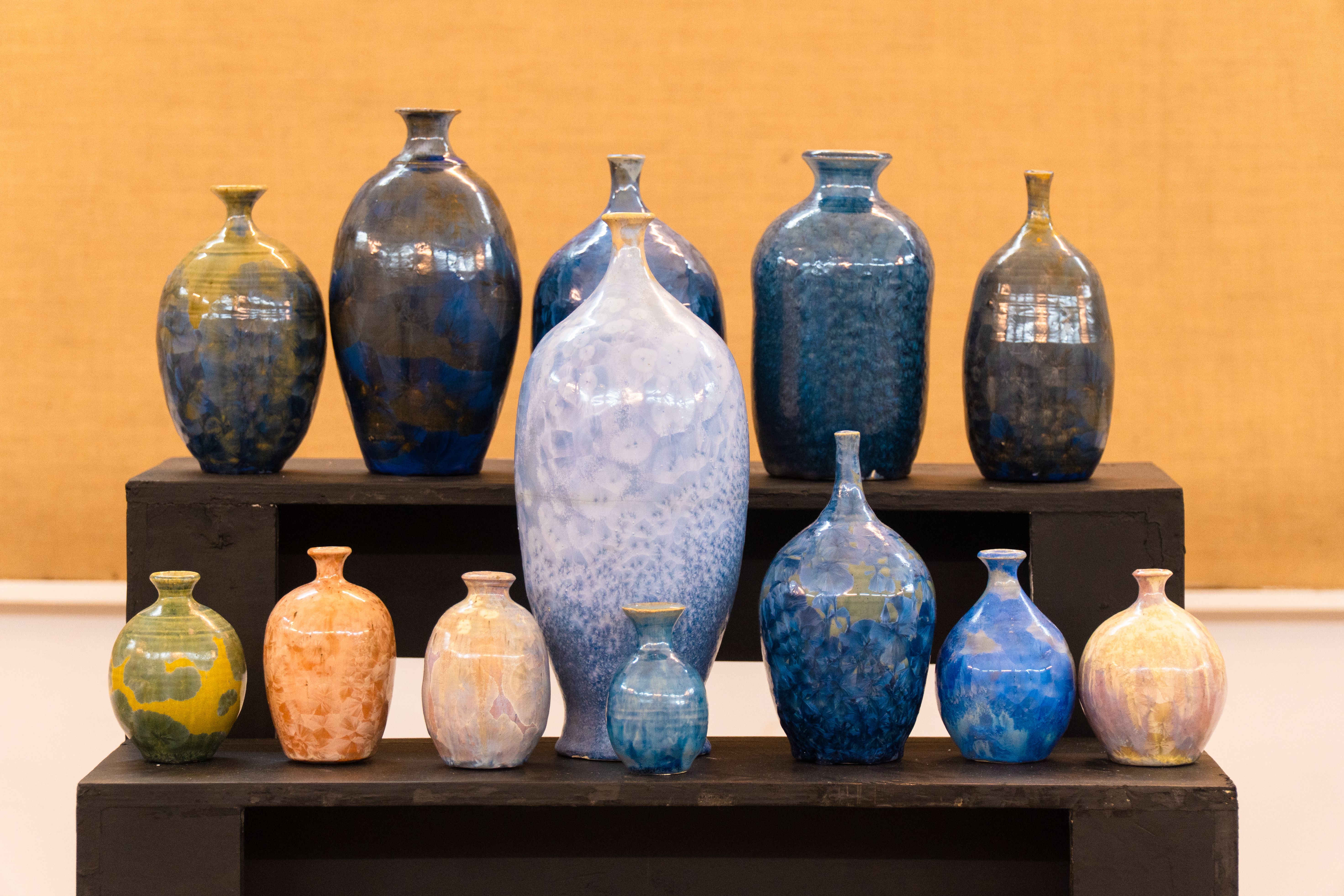 Colorful ceramic vases on display at a Santiniketan art exhibit.