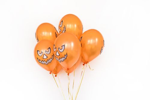 Free Bright orange Halloween balloons with jack-o'-lantern faces, perfect for festive decorations. Stock Photo