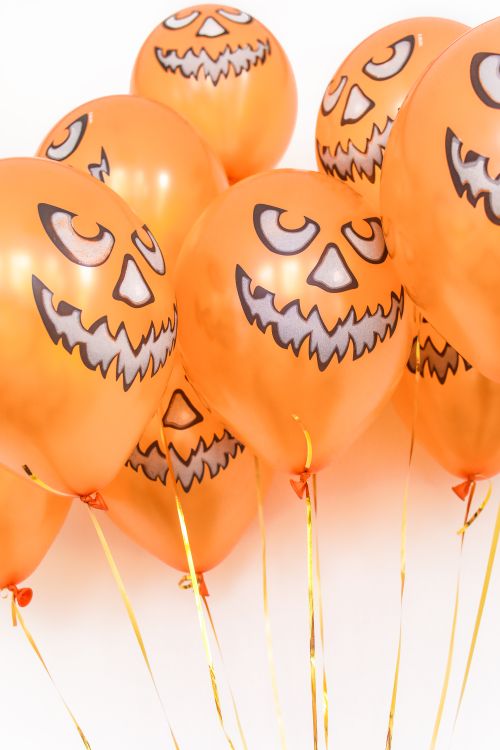 Free Orange balloons with jack-o'-lantern faces for Halloween celebration. Stock Photo