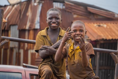 Free Two happy children playing and smiling in a rustic urban environment. Stock Photo