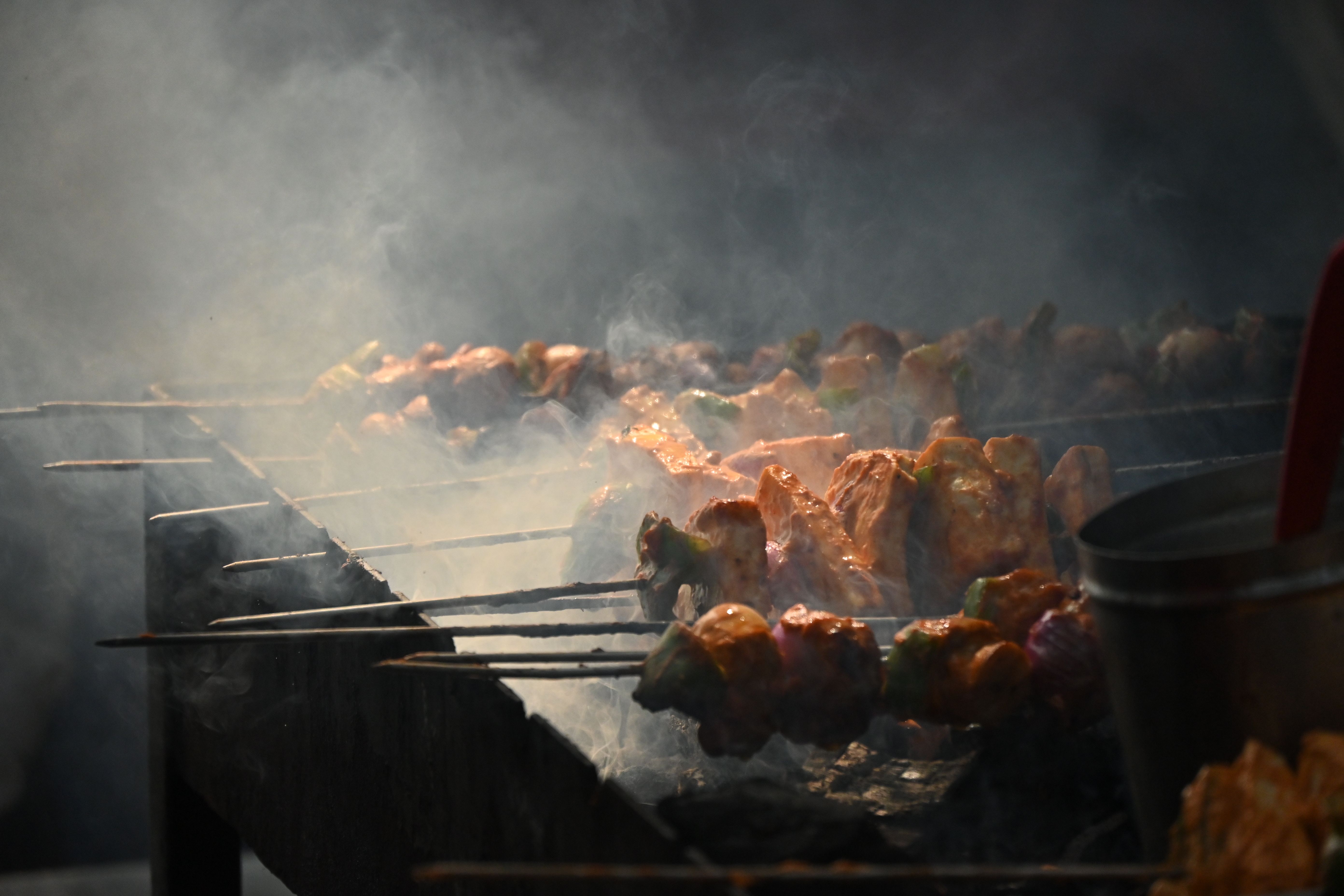 Skewers of marinated meat sizzling over a charcoal grill