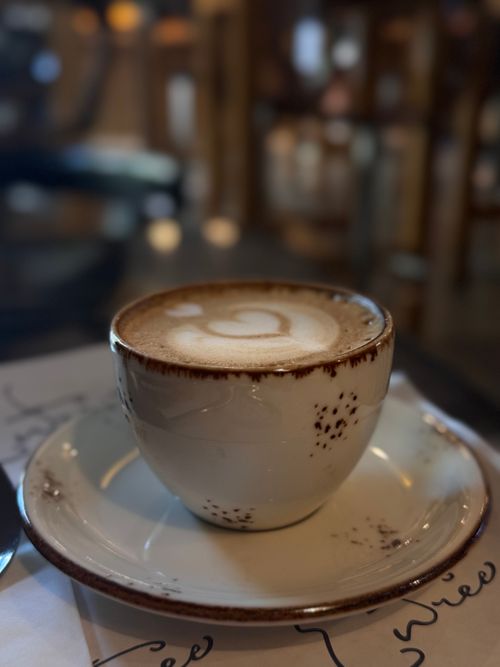 Free A beautifully crafted cappuccino with latte art in a cozy cafe setting. Stock Photo