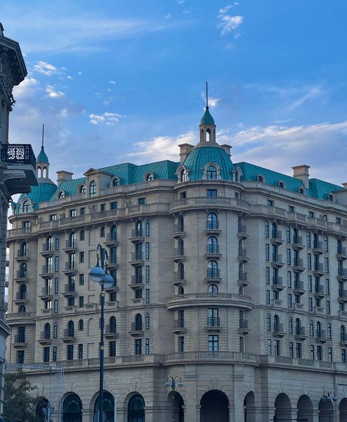Free Stunning view of a grand building with turquoise roofs under a bright blue sky, showcasing elegant urban architecture. Stock Photo