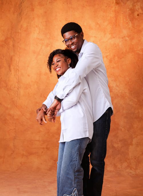 Free Happy couple embraces with smiles against warm, textured background. Stock Photo