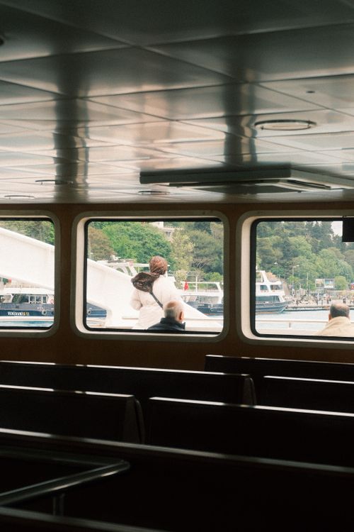 Free Interior view of a ferry with passengers seated, looking out to the marina. Stock Photo