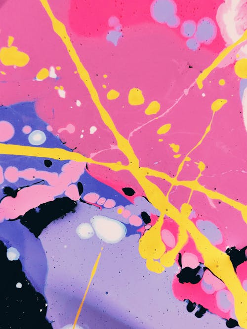 Abstract background of vivid pink and lilac spots and crossed bright yellow paint lines and drops on top