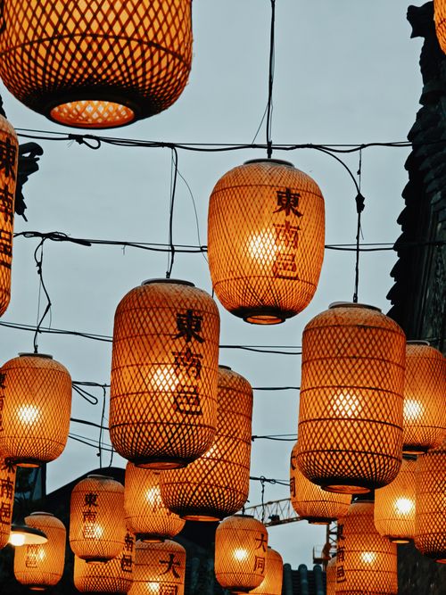 Free Illuminated traditional Chinese lanterns hang beautifully against the evening sky. Stock Photo