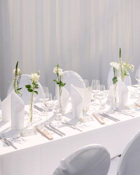 Beautiful white table setup with elegant floral decor, perfect for weddings or formal events.