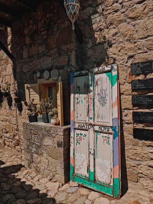 Free Charming old stone café entrance featuring colorful painted doors and potted plants in Adatepe Koyu. Stock Photo