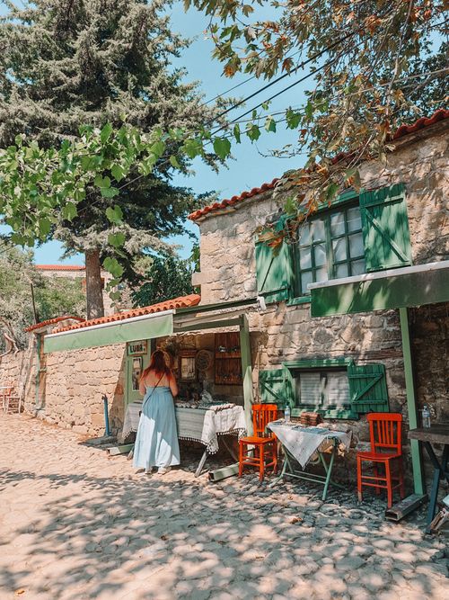 Free Rustic stone cafe on sunny day, woman exploring charming village spot. Stock Photo