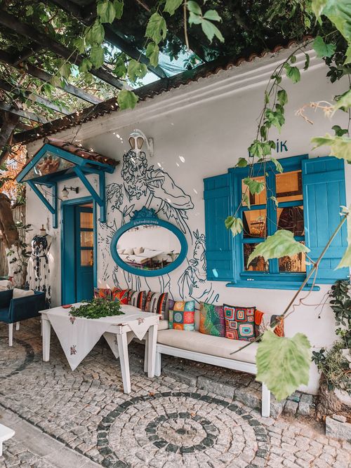 Free Charming outdoor cafe with blue decor and art mural, perfect for a Mediterranean vibe. Stock Photo