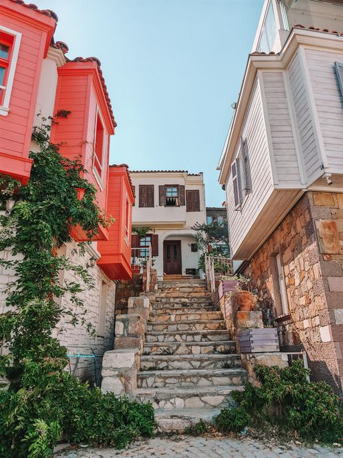 Free Picturesque view of colorful Mediterranean village houses with stone steps leading upward, bathed in sunlight. Stock Photo